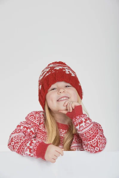 Улыбающаяся красивая блондинка в красной зимней кепке и свитере — стоковое фото