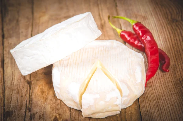 Queso azul maloliente sobre una mesa rústica de madera con chile picante —  Fotos de Stock