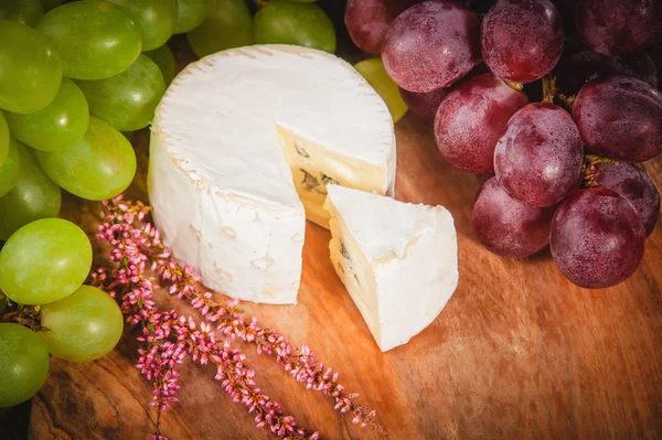 Stinkende blauwe kaas op een rustieke houten tafel met druivenmost — Stockfoto