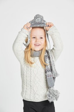 Güzel sarışın kız sıcak kış şapka ve atkı oynamaktan