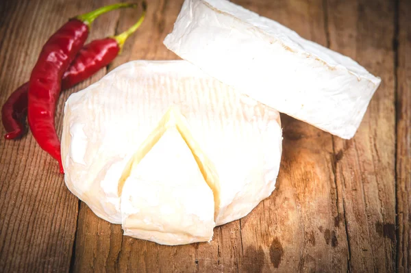 Smelly blue cheese on a wooden rustic table with hot chili peppe — Stock Photo, Image