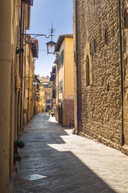 Yaşlı yeşillik bir ortaçağ Tuscan kasaba sokaklarında.