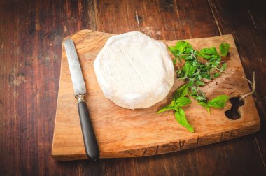 Pis kokulu mavi peynir bıçağı ve fesleğen bir ahşap rustik masada