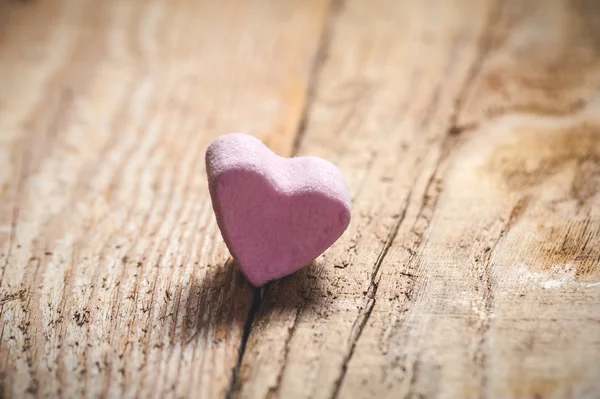 Das rosa Herz auf einem rustikalen Holztisch als Hintergrund — Stockfoto