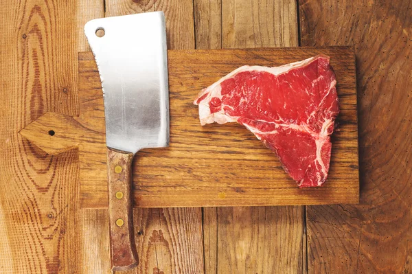 Beautiful and juicy steak on wooden board with cleaver — Stock Photo, Image