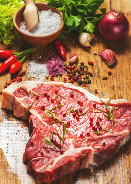 Közeli kép a friss hús steak, fűszerek, fából készült háttér — Stock Fotó