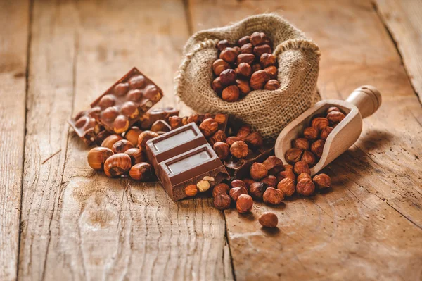 Chocolat au lait avec des noix sur une cuillère en bois dans un style champêtre . — Photo