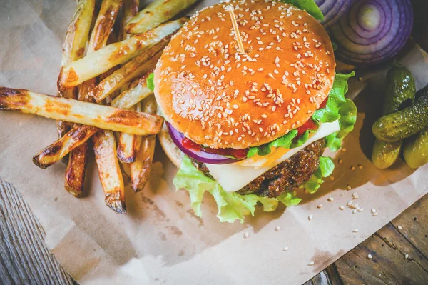 Delicious burger and chips, hand-made in the house on rustic tab Stock Photo