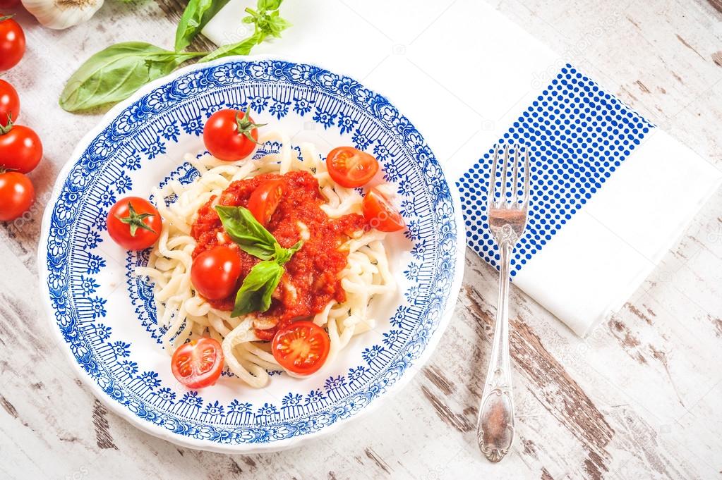 Healthy plate of Italian spaghetti topped with a tasty tomato an