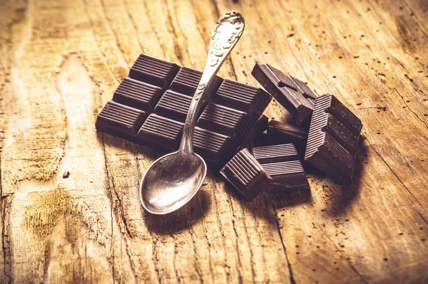 Noble dark chocolate on a wooden table in vintage style. — Stock Photo, Image