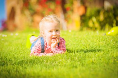 Harika küçük kız yeşil bahar çimenlerin üzerinde çalış