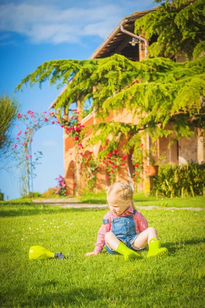 Marvelous little girl plays with on green spring grass — Stock Photo, Image