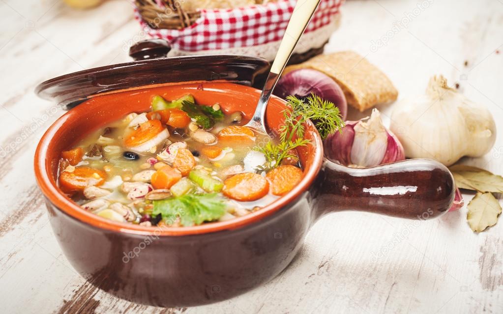 Rural vegetarian broth soup with colorful vegetables and rustic 