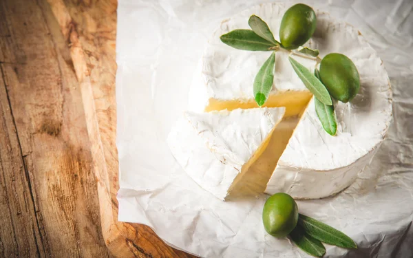 Stinkende camembert kaas op een rustieke houten tafel — Stockfoto