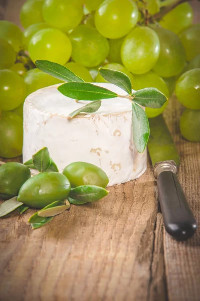 Stinkender Blauschimmelkäse auf einem rustikalen Holztisch mit Trauben — Stockfoto