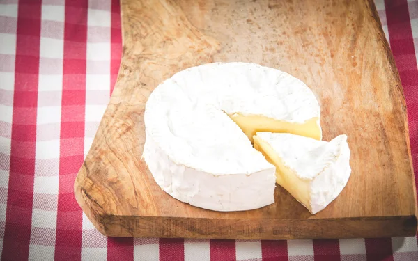 Stinkende camembert kaas op een rustieke houten tafel — Stockfoto