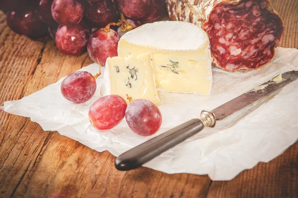 Blauwe kaas met salami op een rustieke houten tafel — Stockfoto