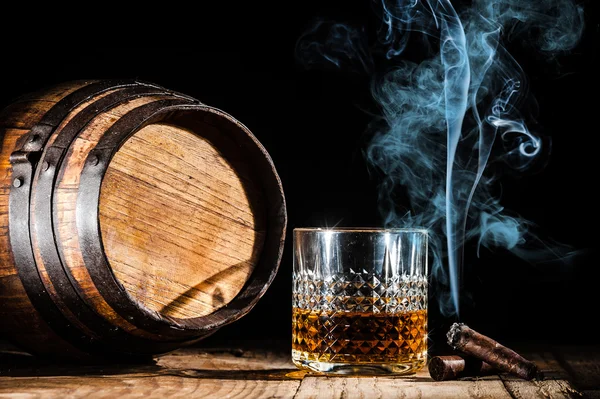 Copo de álcool e fumar charuto nobre em um fundo preto — Fotografia de Stock