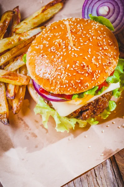 Delicious burger and chips, hand-made in the house on rustic tab Stock Photo