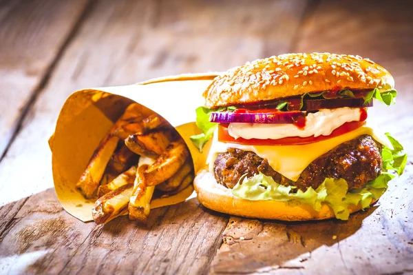 Ízletes burger és a chipek, kézzel készített a házban, rusztikus lapon — Stock Fotó