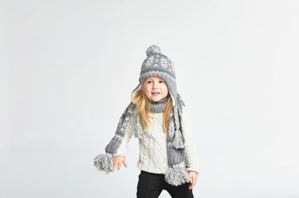 Piękna blond dziewczyna gra w zimie ciepłą czapkę i szalik — Zdjęcie stockowe