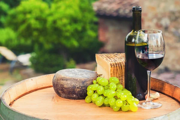 Vino tinto, queso pecorino en un barril de madera en el fondo o —  Fotos de Stock