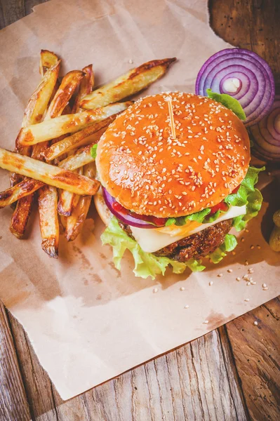 Delicious burger and chips, hand-made in the house on rustic tab Royalty Free Stock Photos