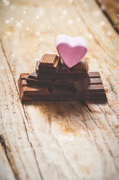 Różowy serce na czarny czekolada z rustykalnym drewniane tła — Zdjęcie stockowe