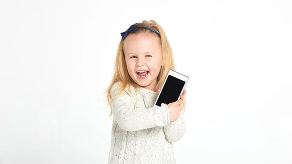 Söt liten flicka leende och använder en smartphone, telefon. — Stockfoto