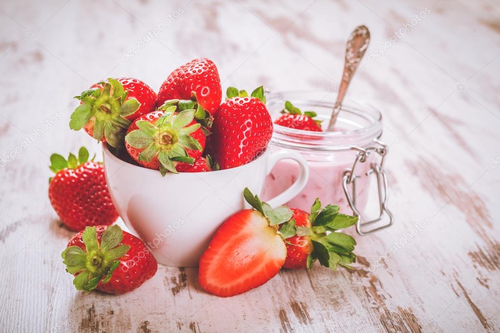 Spring fruits, strawberries with strawberry yogurt on a vintage 