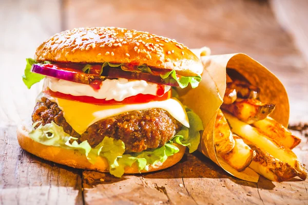 Delicious burger and chips, hand-made in the house on rustic tab — Stock Photo, Image