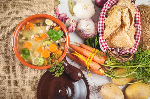 Rural vegetarian broth soup with colorful vegetables and rustic — Stock Photo, Image