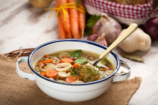 Vegetable soup in a metal bowl on a rural rustic wooden table. — Stock Image Vegetable soup in a metal bowl on a rural rustic wooden table. Royalty Free Stock Photos