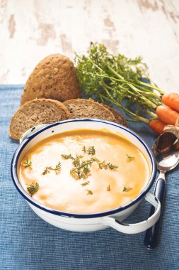 Kabak ve havuç üzerinde mavi bir masa örtüsü içinde ülke arpacık ile çorbası