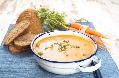 Kabak ve havuç üzerinde mavi bir masa örtüsü içinde ülke arpacık ile çorbası