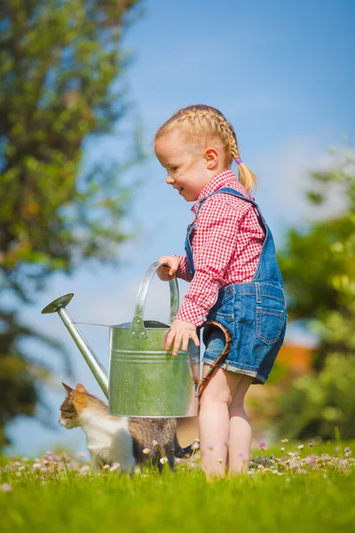 Красива усміхнена маленька дівчинка допомагає у весняній роботі, сад — стокове фото