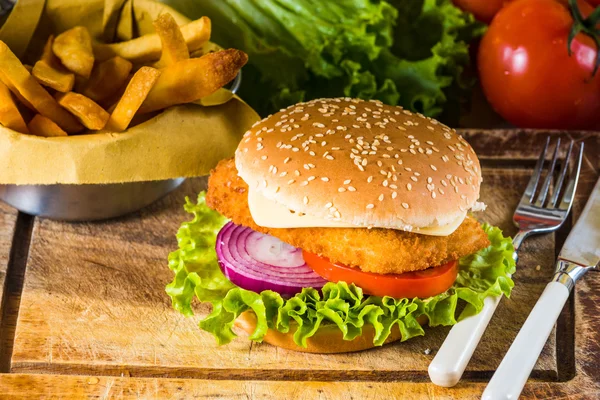 Country-style dish on a wooden table with a chicken burger and f — Stock Photo, Image