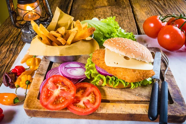Obložený talíř kuřecí burger s čerstvou zeleninou a smaženými hranolky — Stock fotografie