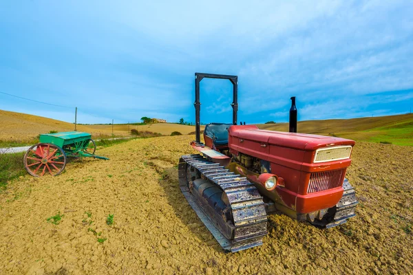 Red tractor on caterpillars on the autumn fields — Stock Photo, Image