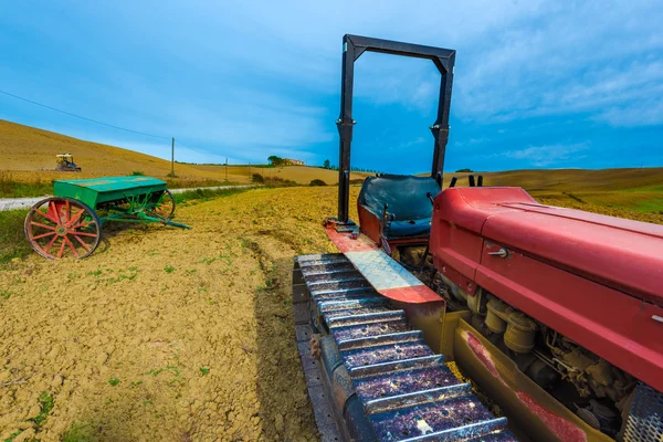 Piros traktor a hernyók az őszi mezők — Stock Fotó