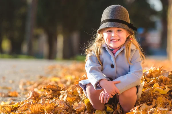 Spacer i blondynka zabawy w jesienny dzień i liści — Zdjęcie stockowe