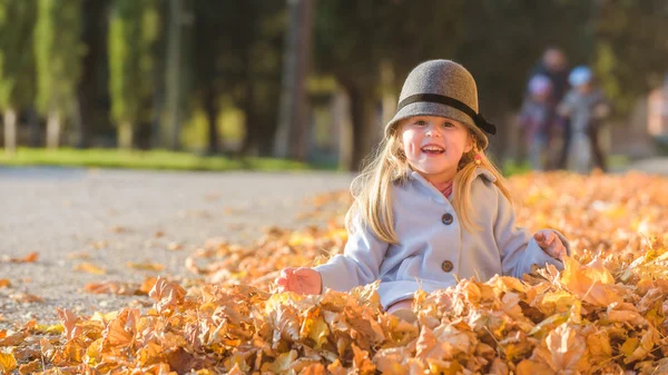 Diversión en hojas chica rubia joven en el día de otoño . — Foto de Stock