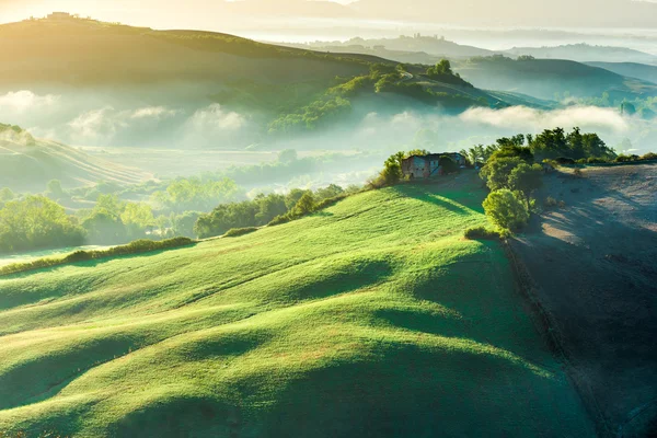 Úžasné mlha na polích v toskánské paprscích slunce, Itálie — Stock fotografie