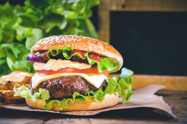 Sulu ve kokulu hamburger vintage tabl üzerinde ev yapımı patates kızartması ile