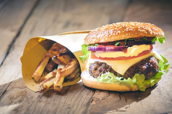 Hamburger succoso e profumato con patatine fritte fatte in casa su tabl vintage — Foto Stock