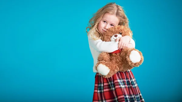 Сказочная маленькая девочка обнимает коричневого плюшевого медведя . — стоковое фото