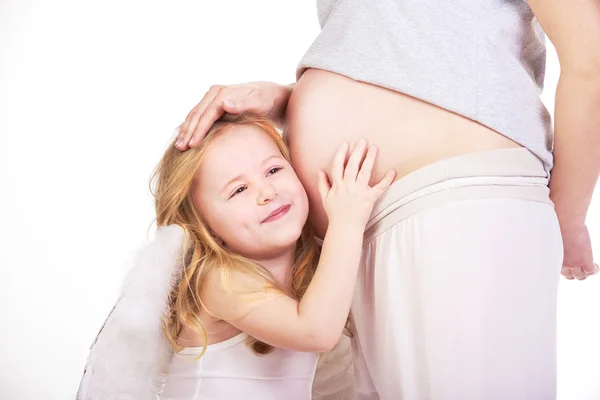 Lovely blond model hair angel hugs pregnant belly. — Stock Photo, Image