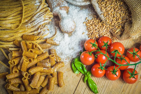 Pastas integrales con ingredientes y tomates . — Foto de Stock