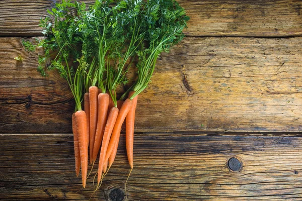 Соковита пучка моркви на сільському дерев'яному столі . — стокове фото