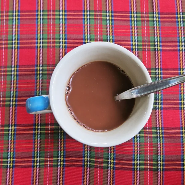 Šálek kávy na pruhovaný vzor barevný ubrus pozadí — Stock fotografie